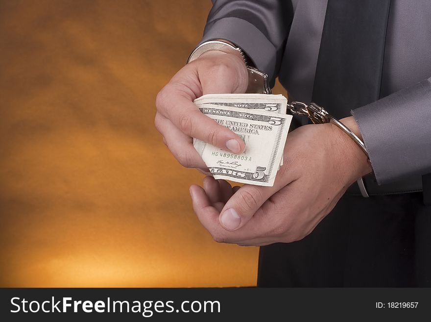 Arrest, close-up man's hands with money in handcuffs. Arrest, close-up man's hands with money in handcuffs.