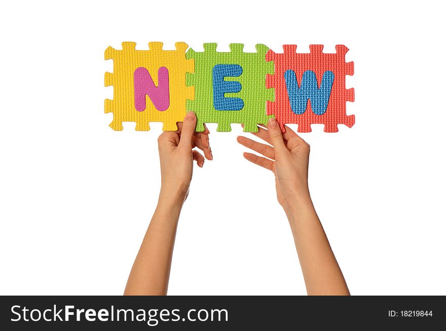 Teacher holding in the hand the amusing colored educational puzzles with the word new