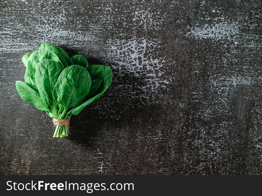 Fresh Spinach Leaves Bouquet . gray background. Copy space. Vegetarian diet concept. Green vegetables. Healthly food