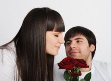 Pretty Woman Smelling Roses, Her Boyfriend Behind Royalty Free Stock Image