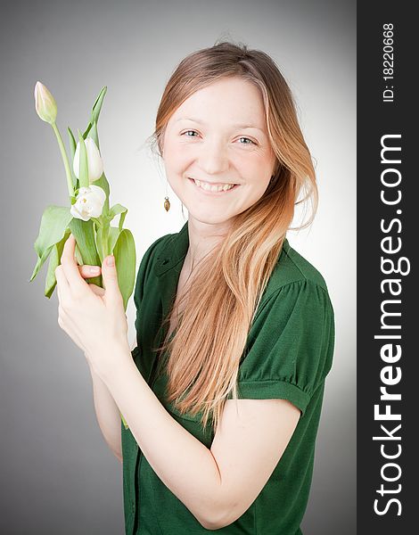 Young girl with tulips, with grey background. Young girl with tulips, with grey background