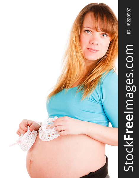 Beautiful pregnant woman with baby's bootees on white background