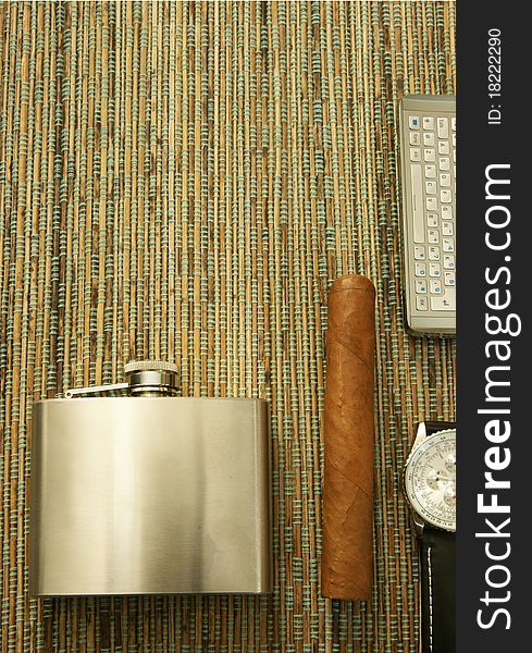 Close up of cigar, hip flask, wristwatch and phone. Background. Close up of cigar, hip flask, wristwatch and phone. Background