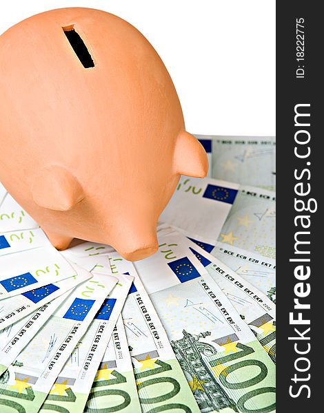 Clay piggy bank on a pile of European banknotes