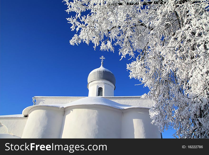 Tree in snow against christian church