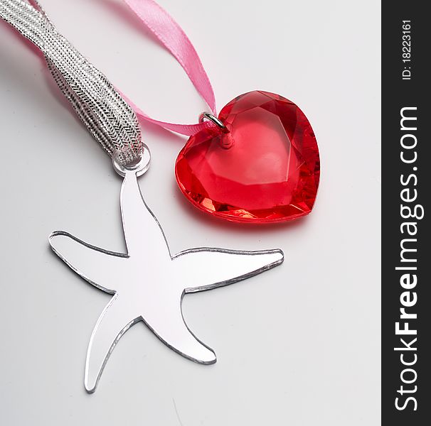 Pink heart of stone and silver star on a gray. Pink heart of stone and silver star on a gray