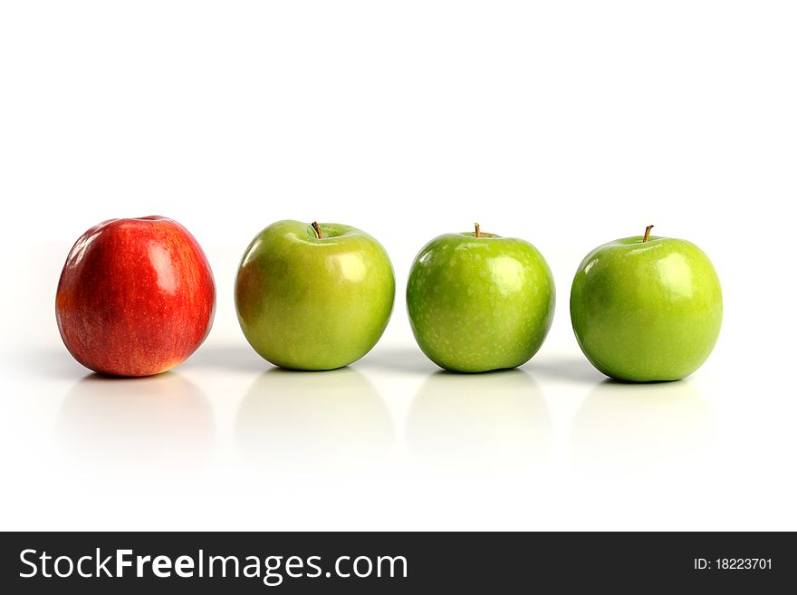 Red apple among green apples isolated on a white background