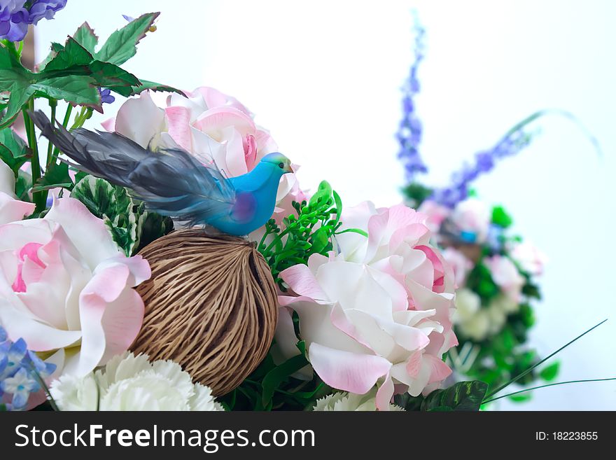 Little bird in artificial flowers.