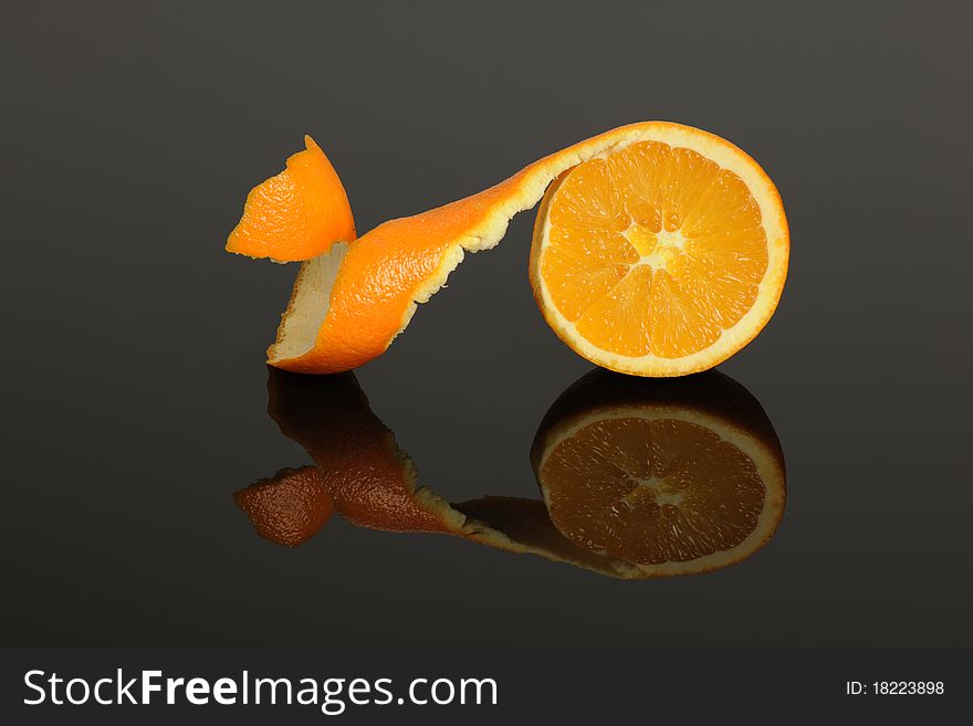 Half Orange peeled isolated on a gray reflective surface