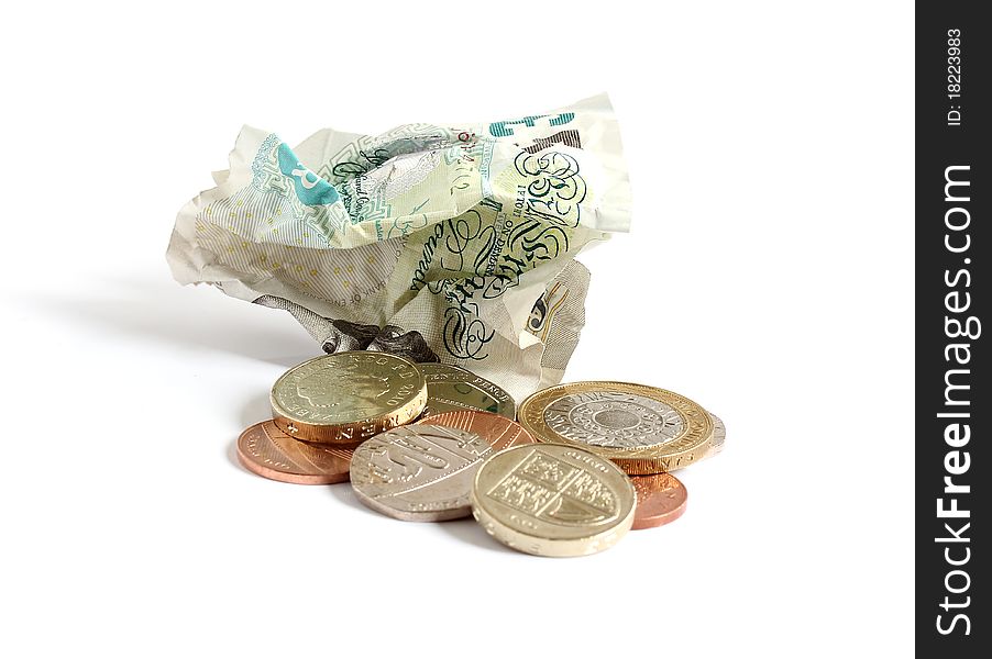 Scrunched up paper money and loose change isolated on white background