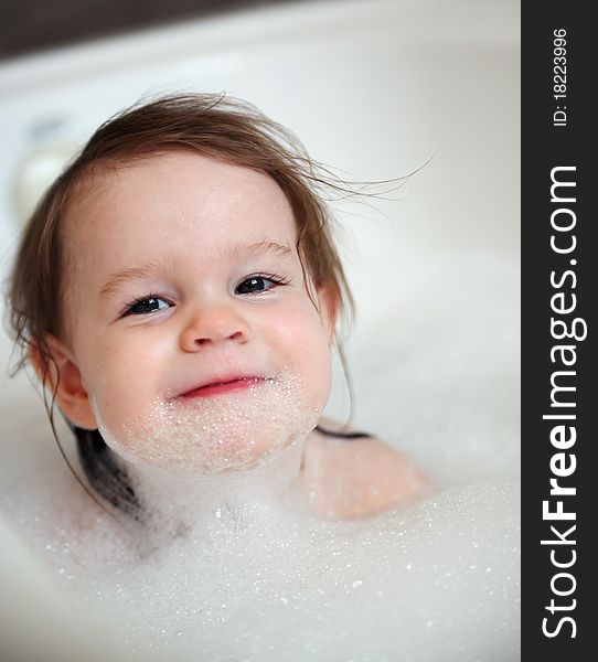 Little toddler girl in a bubble bath with soap on her face. Little toddler girl in a bubble bath with soap on her face