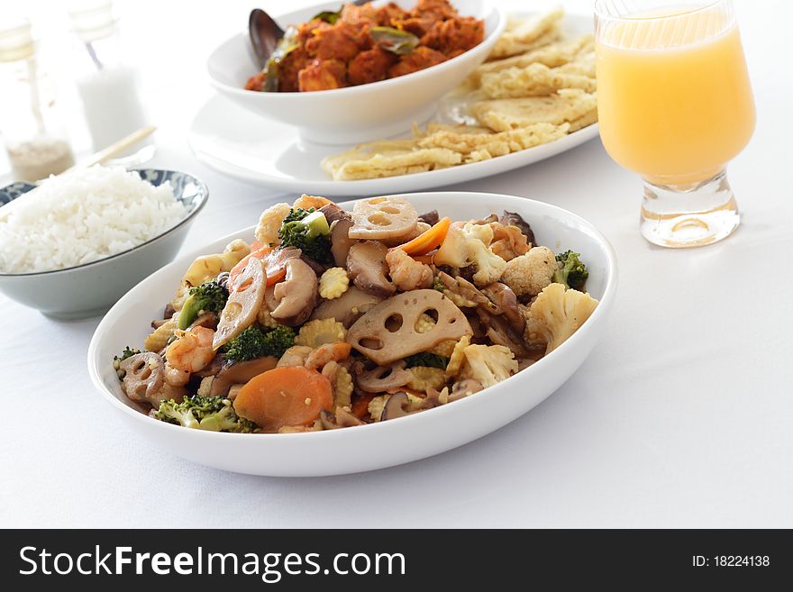 A dish of mixed vegetables with other dishes in the background