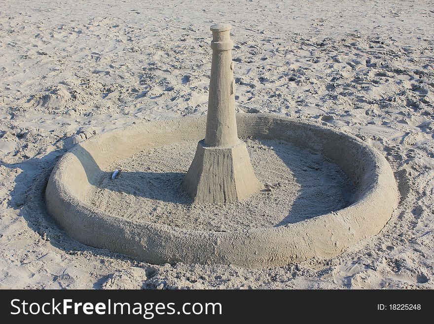 Lighthouse out of sand with a wall around