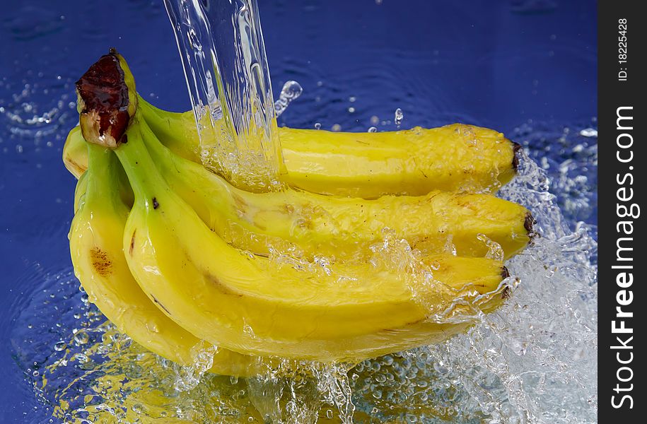 Banana and splash water over blue background