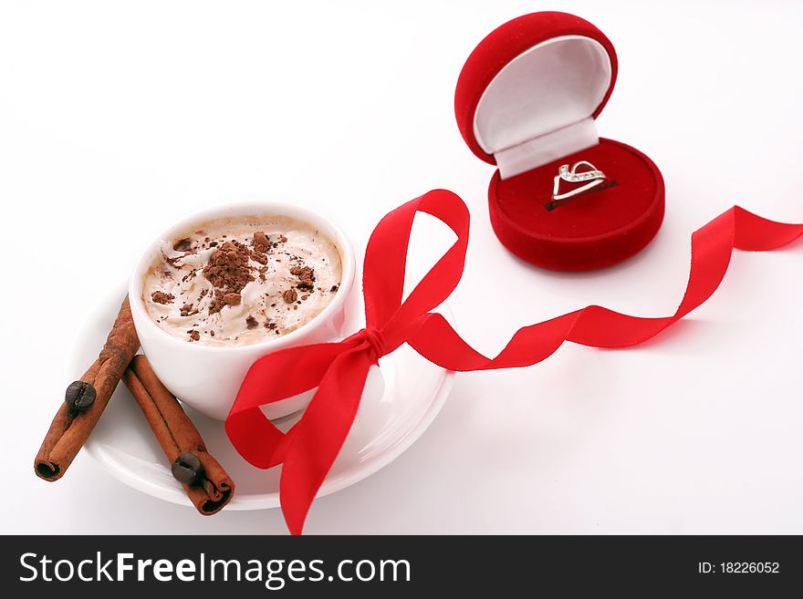 Cup of coffee with a red ribbon and a ring. Cup of coffee with a red ribbon and a ring