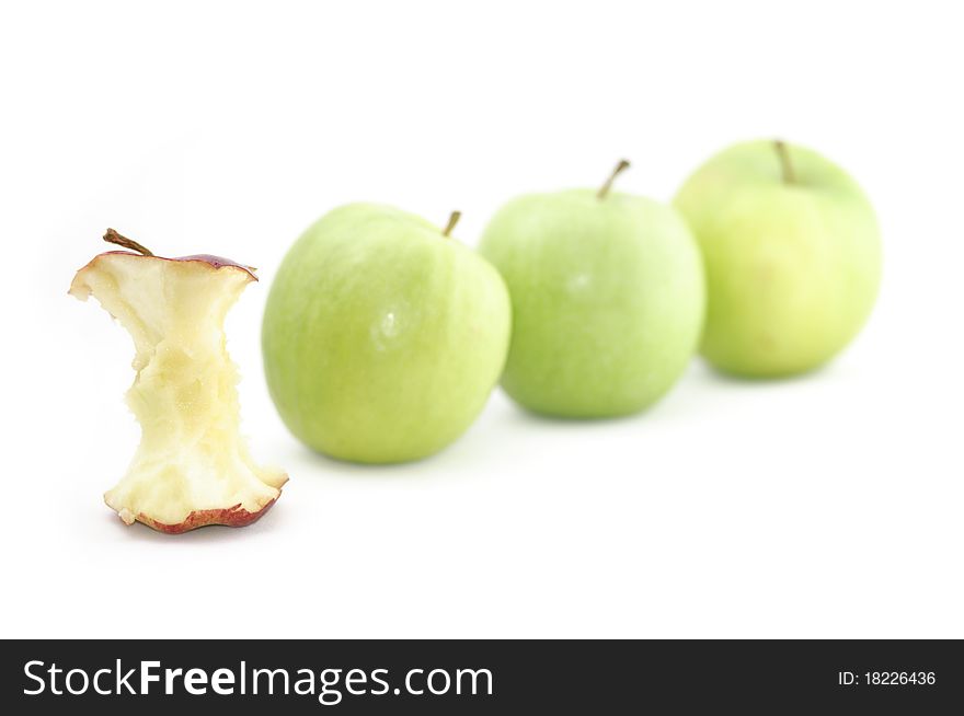 A red apple is singled out and devoured for being different to its green counterparts. Could be used to illustrate a variety of concepts. Isolated on a white background.