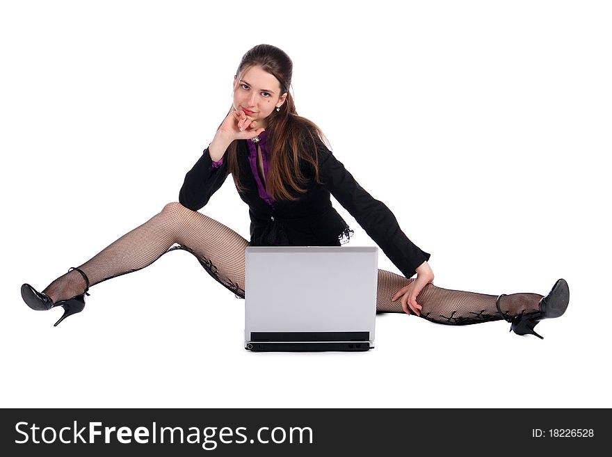 Girl in black suit with notebook sits on floor.