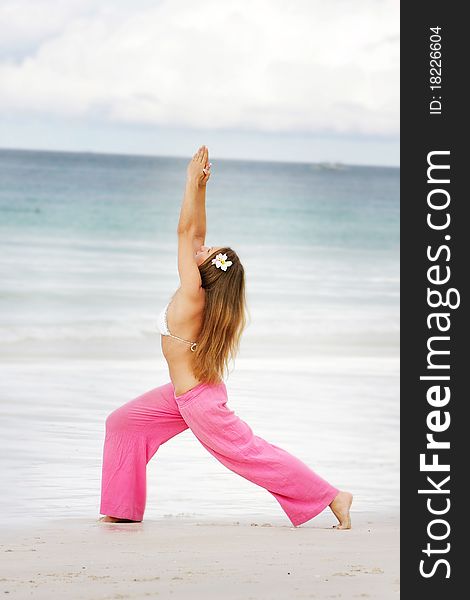 Young Woman Doing Yoga On Beach