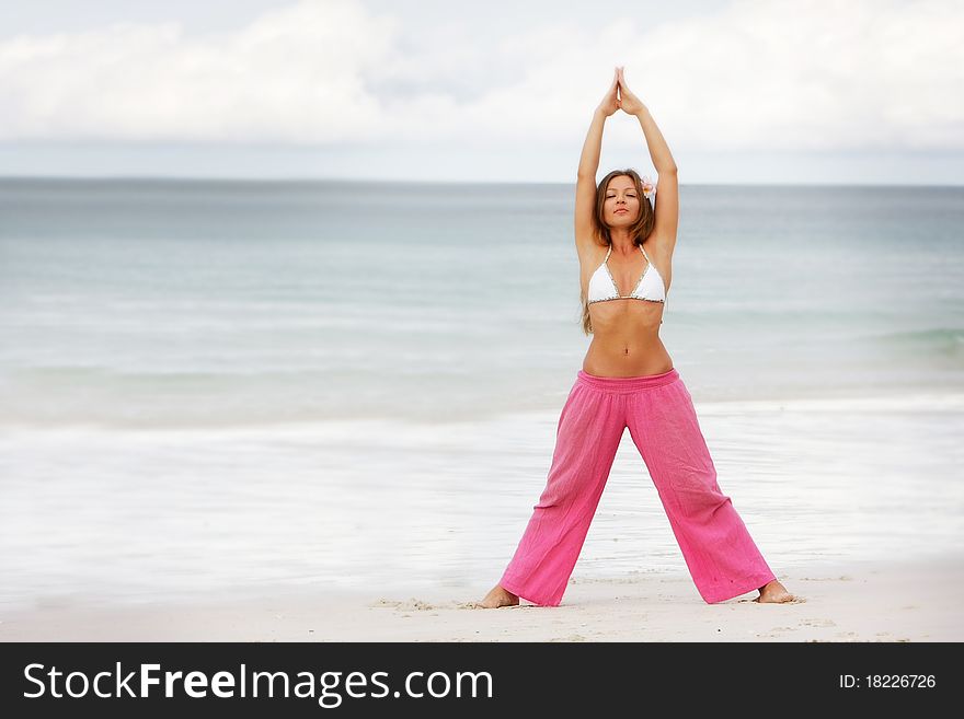 Young Woman Doing Yoga On Beach