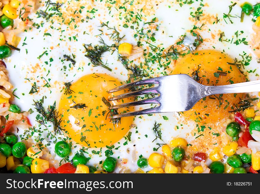 Fried eggs with vegetables, close-up