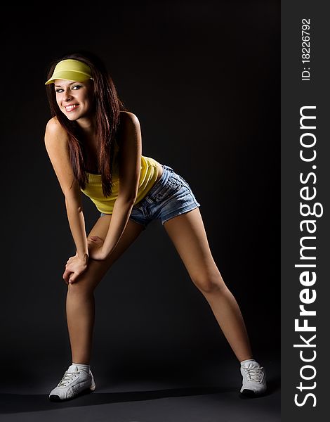 Young sexy sports woman posing on dark background