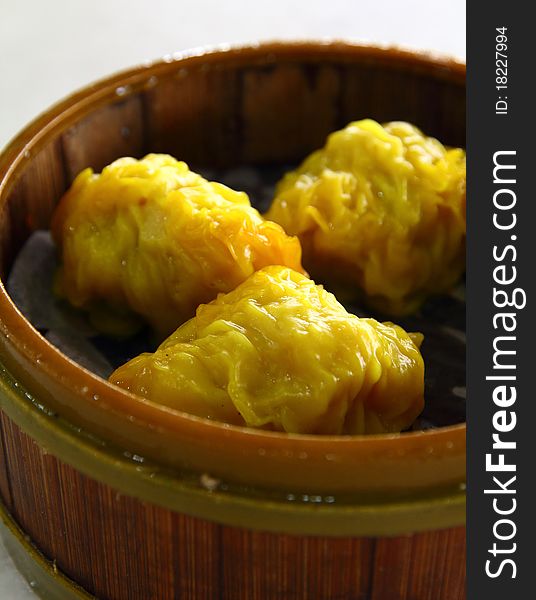 Delicious Yellow Colored Oriental Dim Sum on wooden tray. Delicious Yellow Colored Oriental Dim Sum on wooden tray.