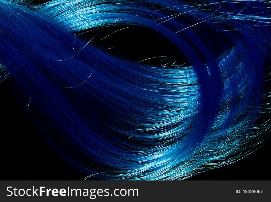 Abstract photo of tie blue artificial hair laying on black background