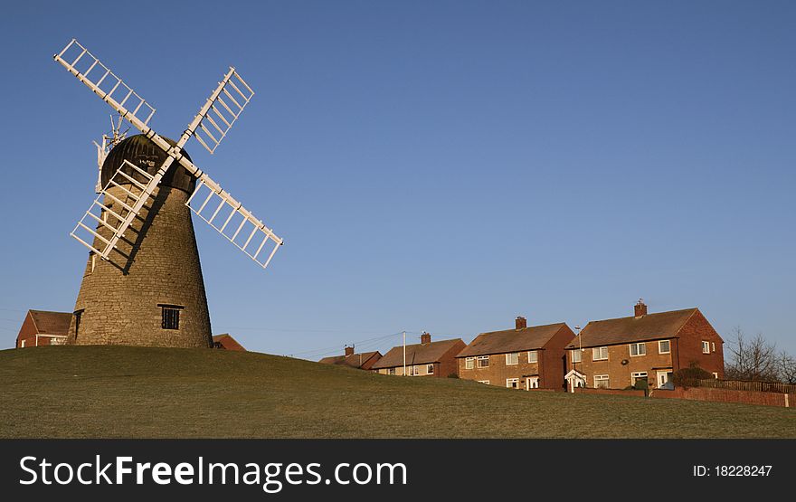 Photograph of a traditional windmill sited close to a residential area. Photograph of a traditional windmill sited close to a residential area.