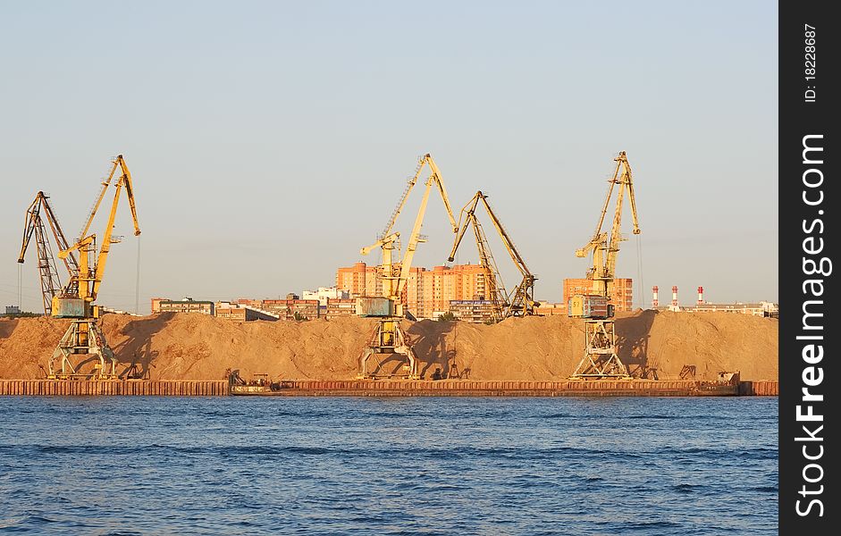 Yellow dock cranes in the river port of Moscow. Photo taken at sunset. Yellow dock cranes in the river port of Moscow. Photo taken at sunset.