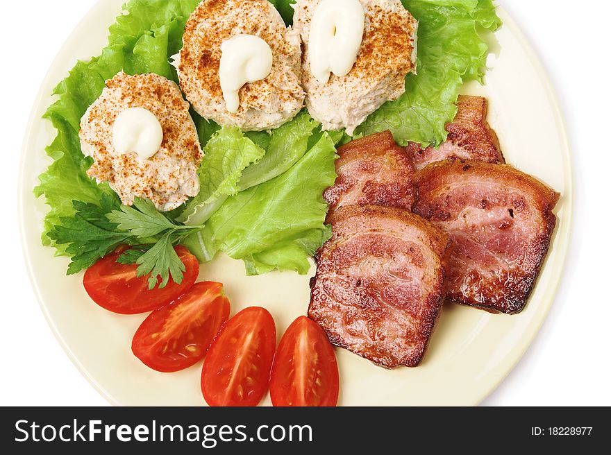 Pork, stuffed eggs, tomatoes and lettuce on a plate. Pork, stuffed eggs, tomatoes and lettuce on a plate.