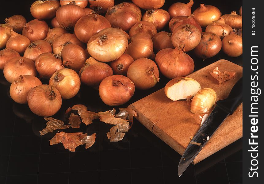 Onion with knife and cutting board on black background. Onion with knife and cutting board on black background