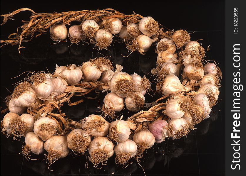 Wreath of garlic on black background