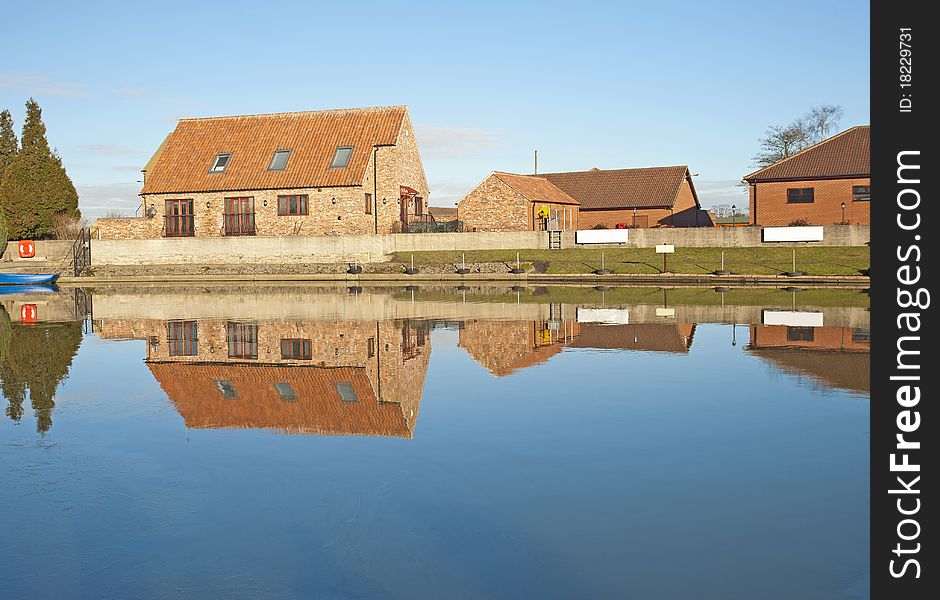 Houses Next To A River With Reflection