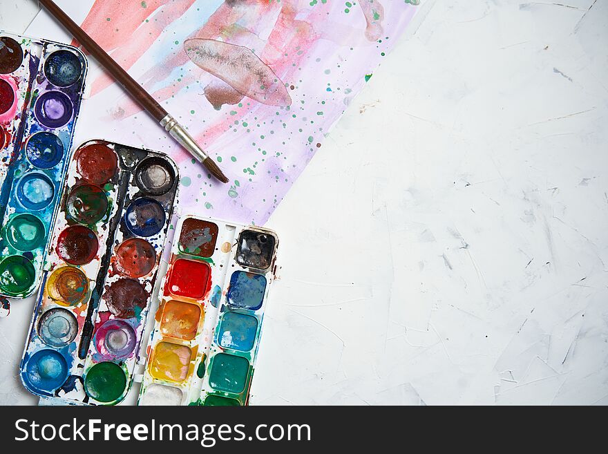 Set of watercolor paints white background. Brushes drawing. Creative background. School for teaching drawing. With copy space for text. Set of watercolor paints white background. Brushes drawing. Creative background. School for teaching drawing. With copy space for text