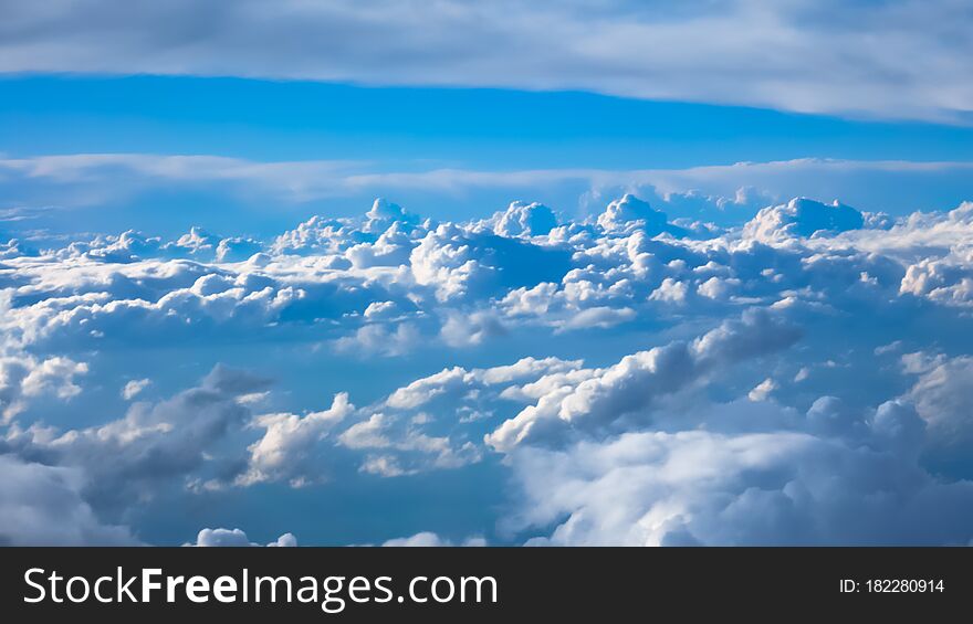 Nice footage of aerial view above clouds from airplane window with blue sky. View from the airplane window to the blue sky and white clouds.