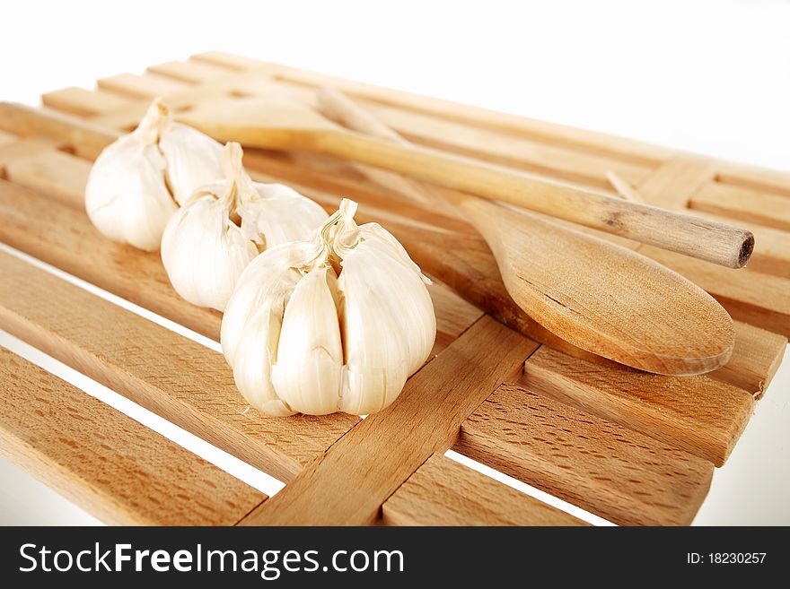 Garlic and ladles on a wooden plate