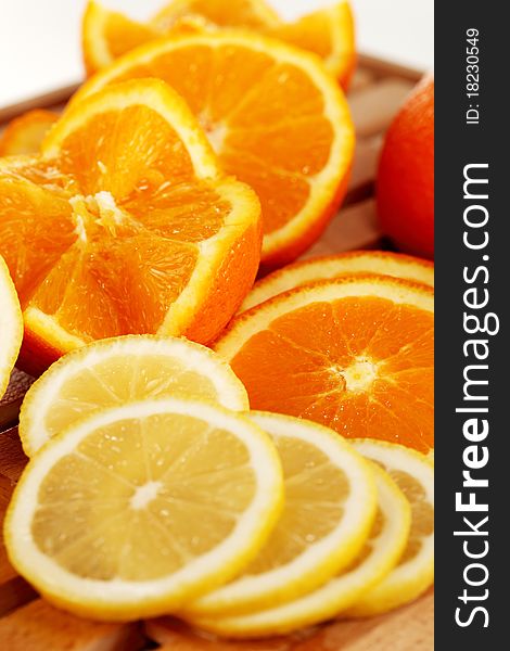 Orange and lemon slices on a wooden plate. Orange and lemon slices on a wooden plate