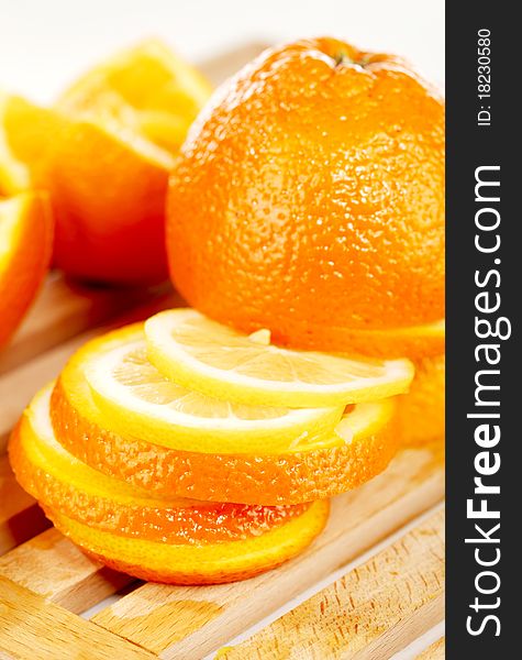 Slices of an orange placed on a wooden plate. Slices of an orange placed on a wooden plate