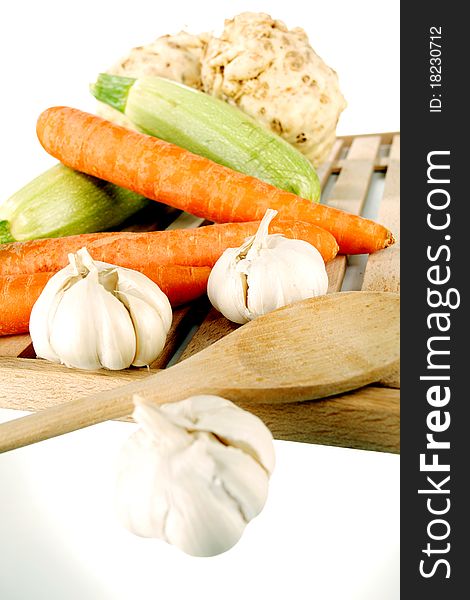 Vegetables on a wooden plate on a white background. Vegetables on a wooden plate on a white background