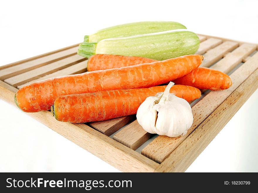 Vegetables on a wooden plate on a white background. Vegetables on a wooden plate on a white background