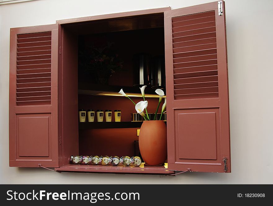 Open window with flowers and coffee cups