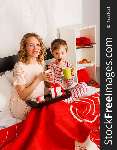 Woman With Her Son Breakfast In A Bed