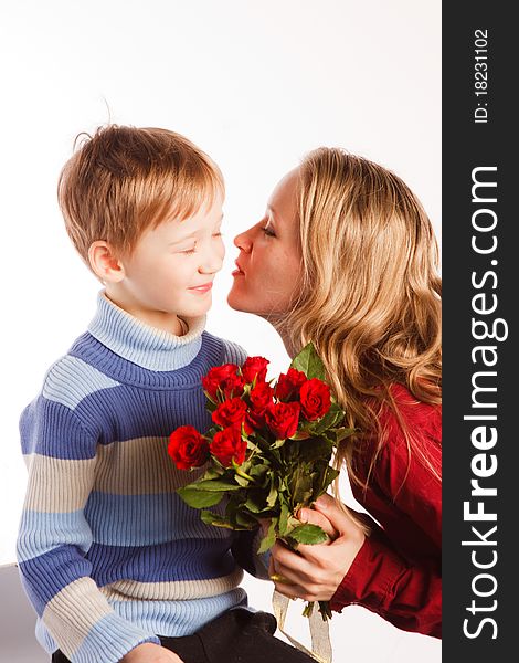 Charming beautiful young woman with a son and with the bouquet of red roses on a white background