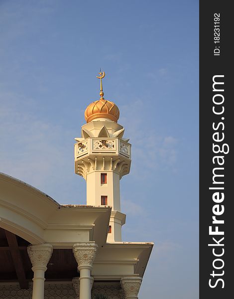 Golden Muslim tower near church