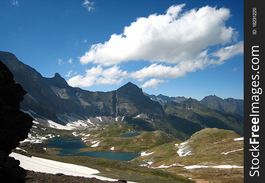 Small lakes and snow surrounded by high rocky mountains