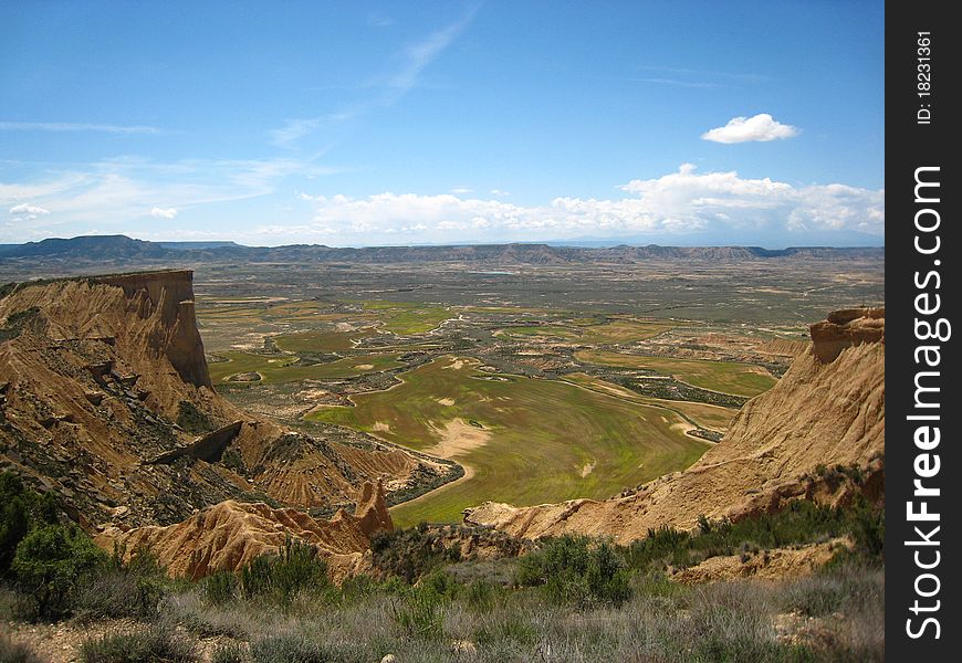 Green and brown wheat fields from a hill in a desert in North of Spain