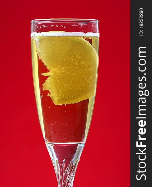 Bubbly lemon drink isolated on red background.