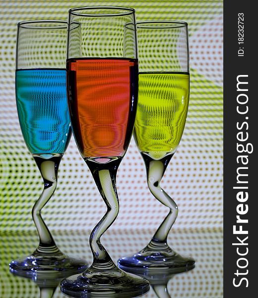 Three glasses of colorful liquour with curved stems. Three glasses of colorful liquour with curved stems