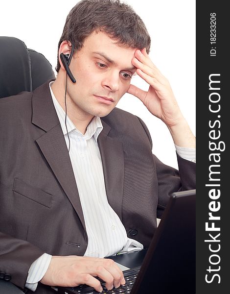 Close Up of a businessman with headset. He is working on laptop