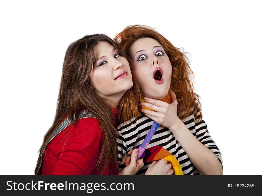 Two funny angry girls. One of them strangle to other. Studio shot.